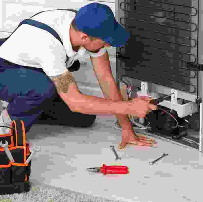 Technician repairing plumbing system with tools, showcasing expertise in handyman services for residential and commercial needs.